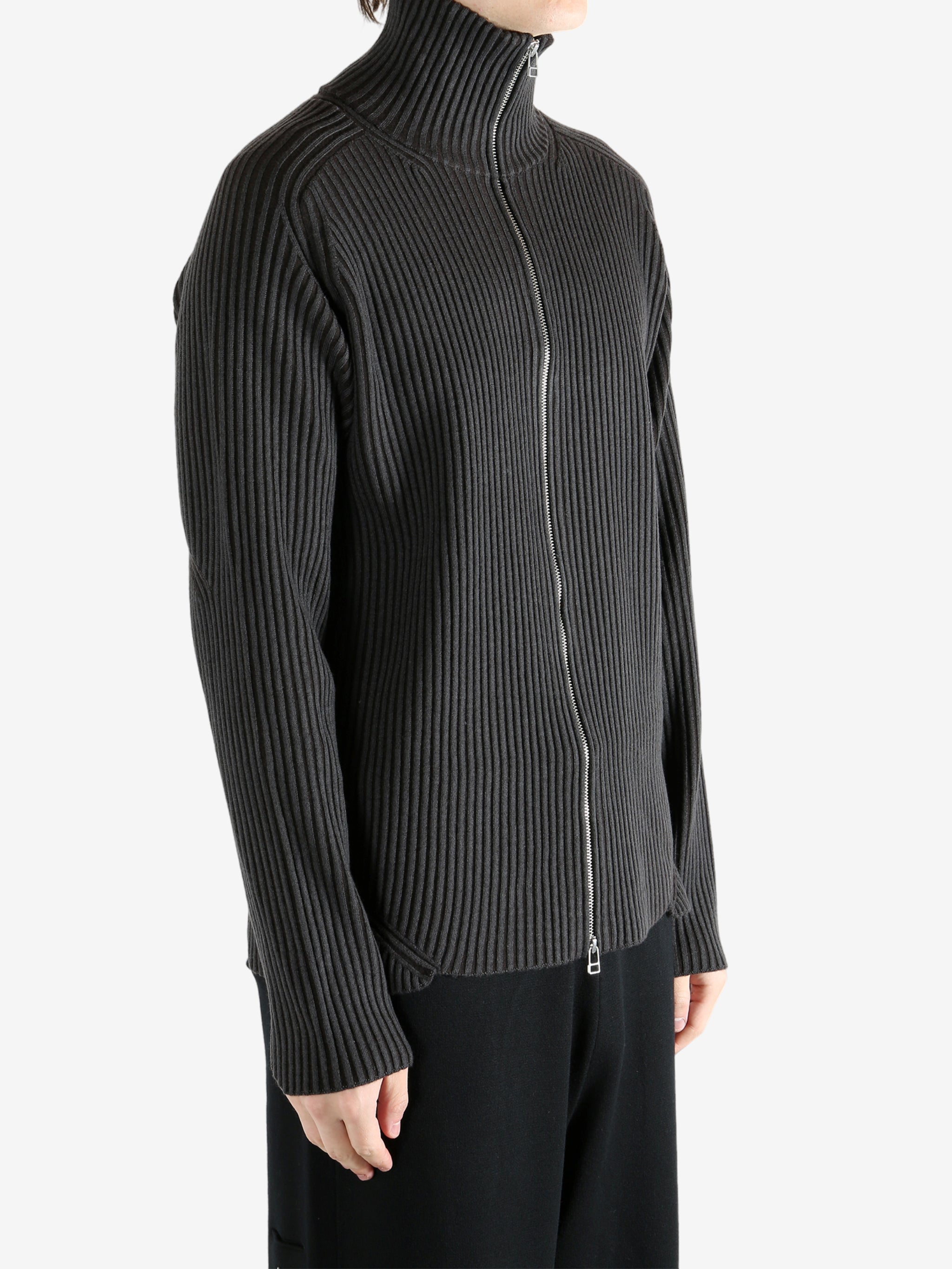 Black knitwear worn by a person, showing the knitwear's fit