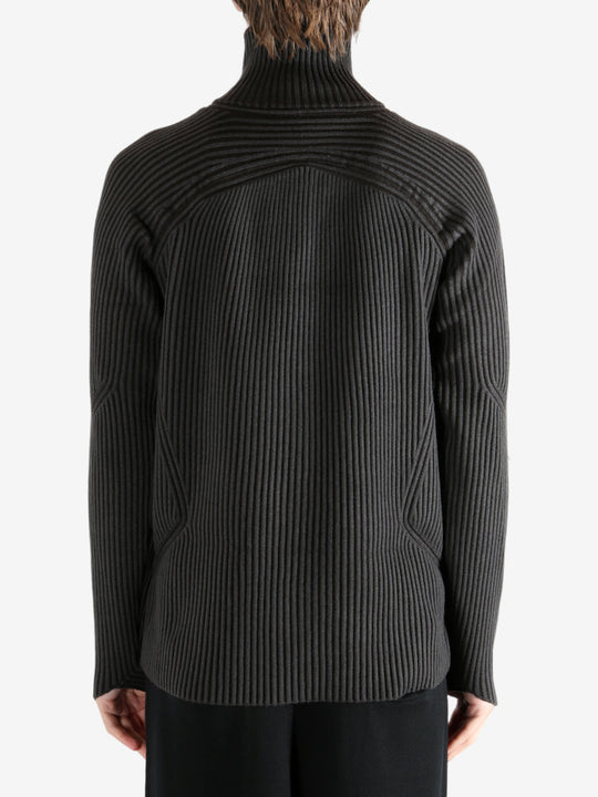 Black knitwear worn by a person, showing the knitwear's fit