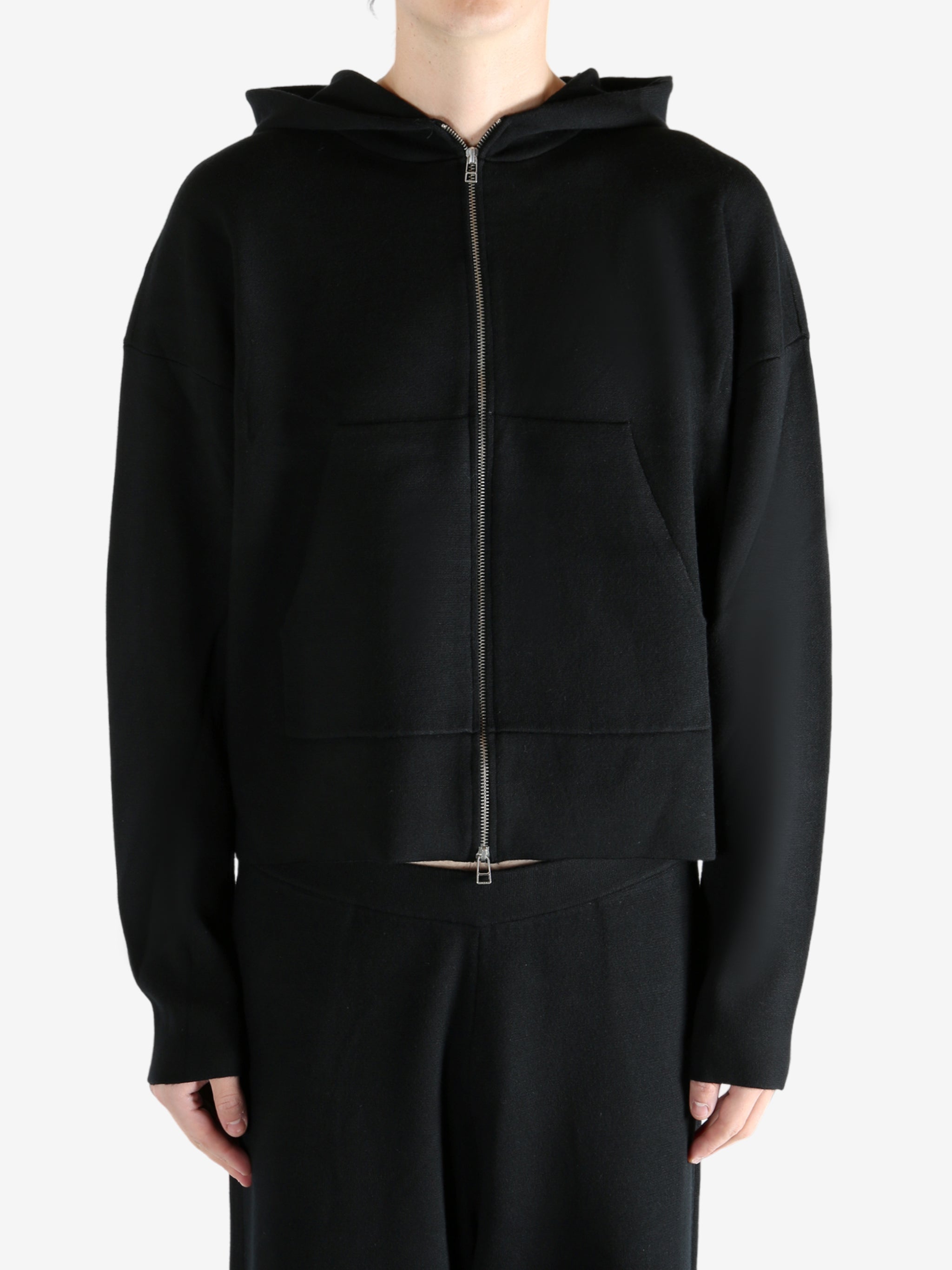 Black knitwear worn by a person, showing the knitwear's fit