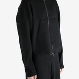 Black knitwear worn by a person, showing the knitwear's fit