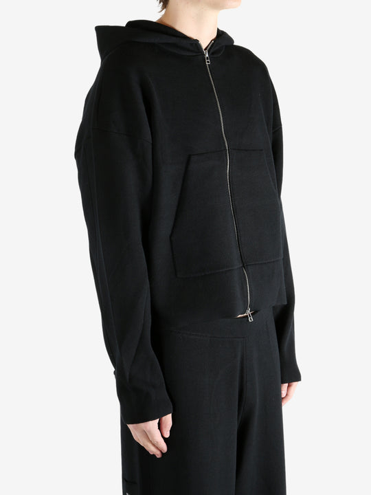 Black knitwear worn by a person, showing the knitwear's fit