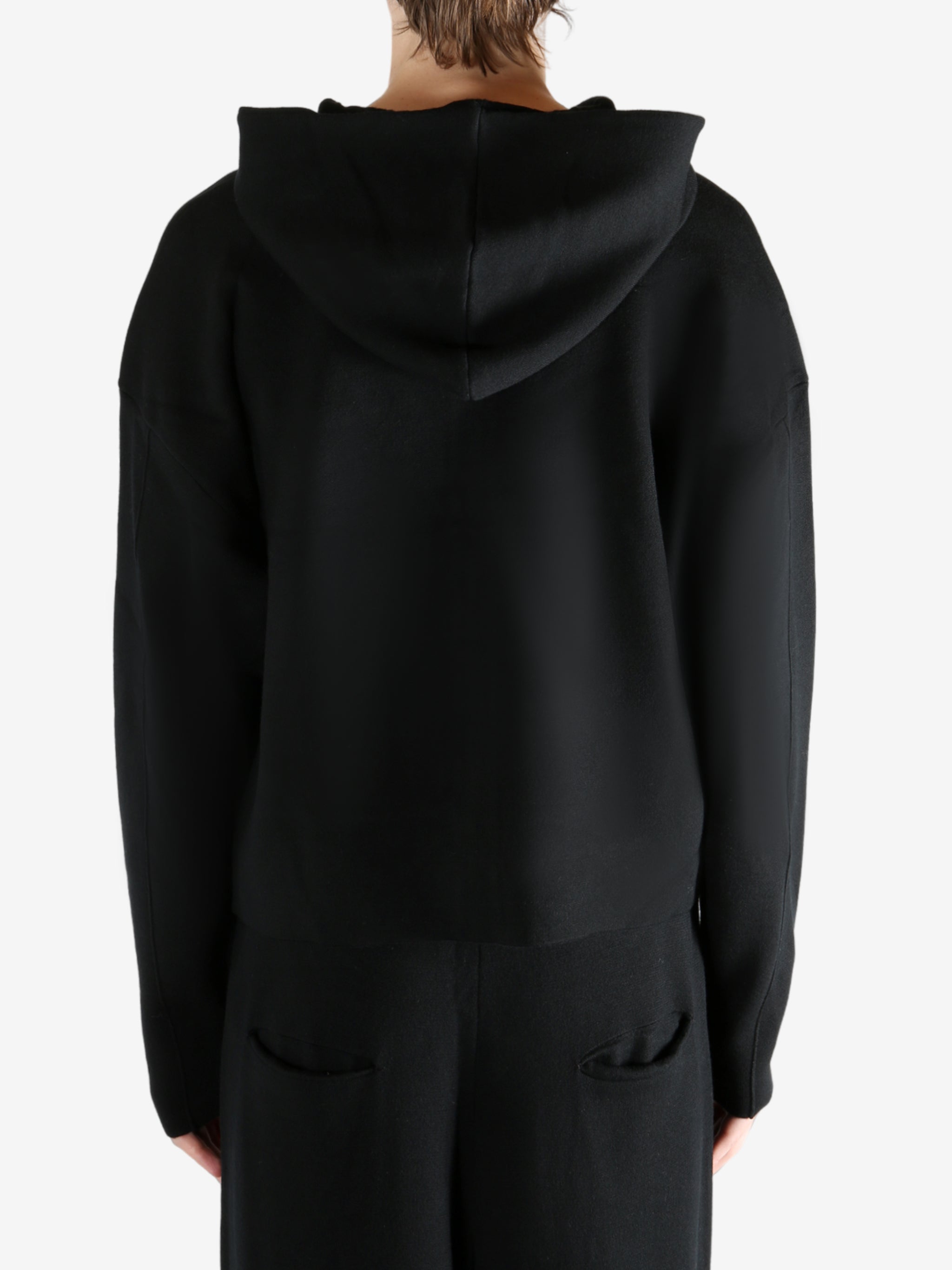 Black knitwear worn by a person, showing the knitwear's fit