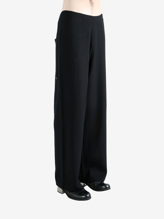 Black pants worn by a person, showing the pants's fit