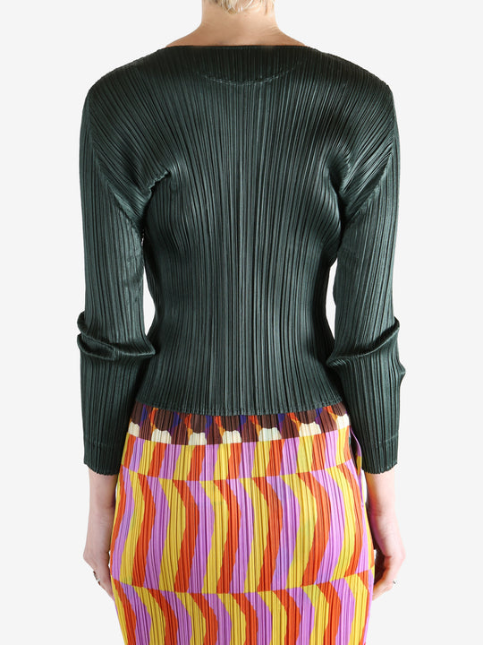 green ribbed sweater worn by a person, showing the sweater fit