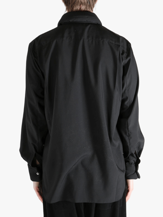 Black shirt worn by a person, showing the shirt's fit