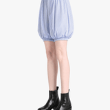 Blue shorts worn by a person, side view