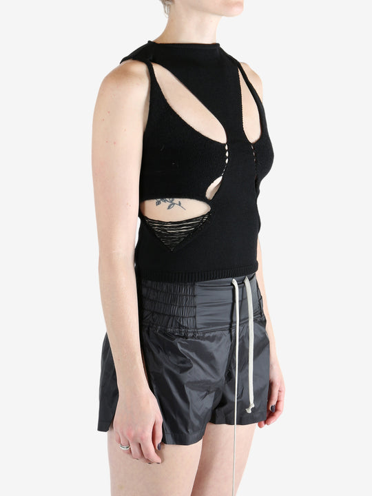 Black top worn by a person, showing the tops's fit