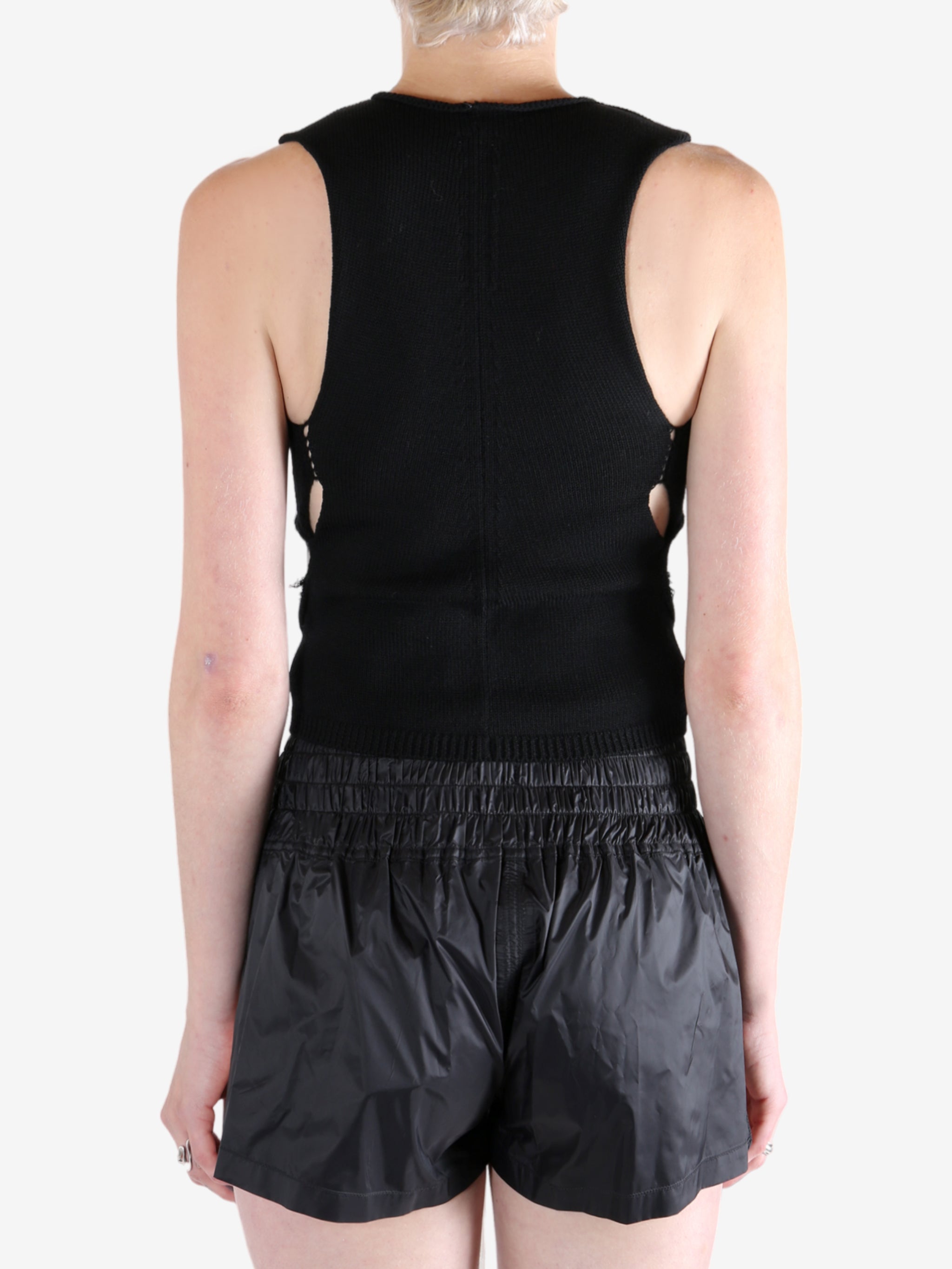 Black top worn by a person, showing the tops's fit