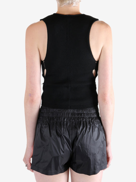 Black top worn by a person, showing the tops's fit