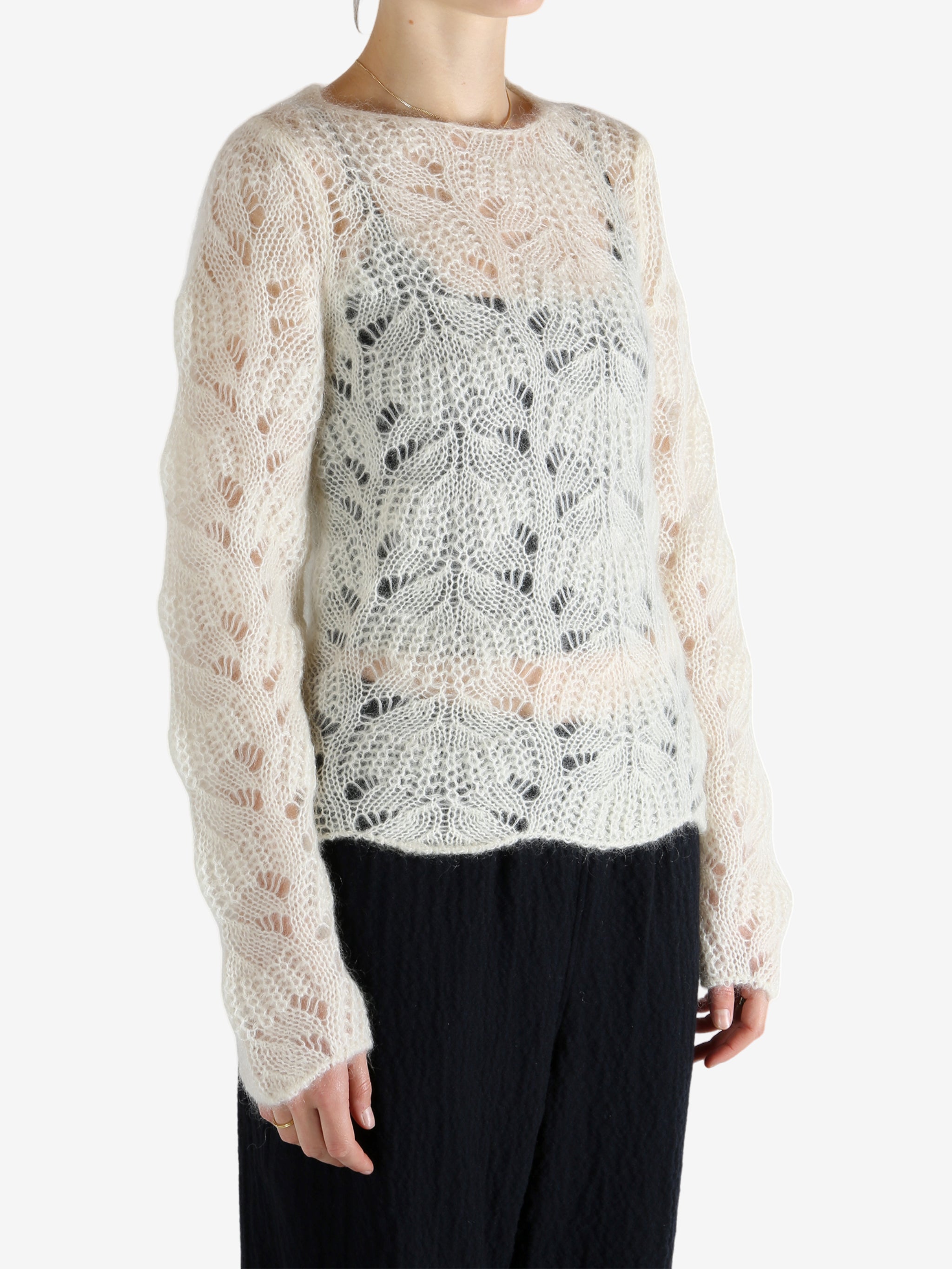 White sweater worn by a person, showing the sweater's fit