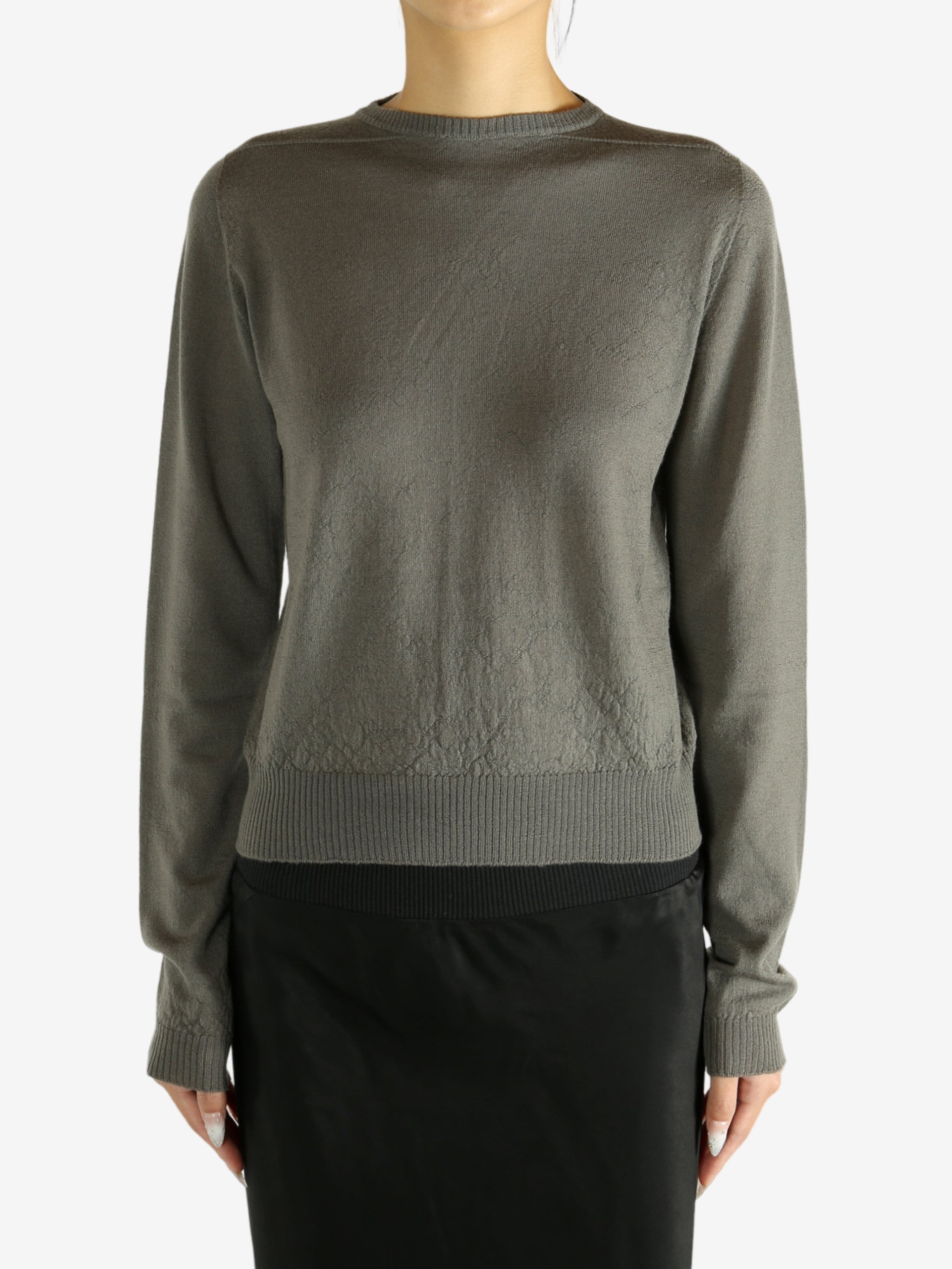 Grey knitwear worn by a person,showing the knitwear's fit