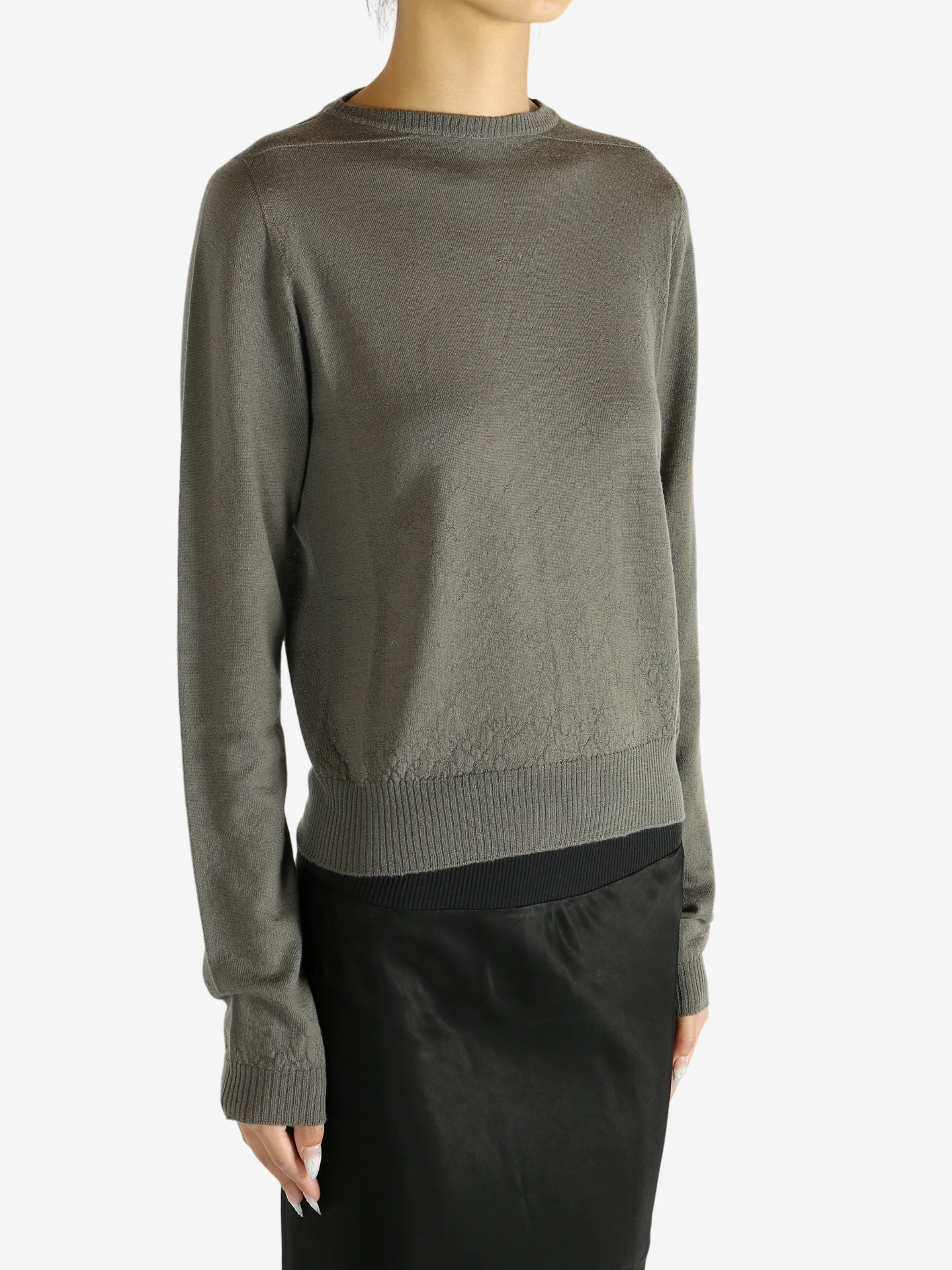 Grey knitwear worn by a person,showing the knitwear's fit