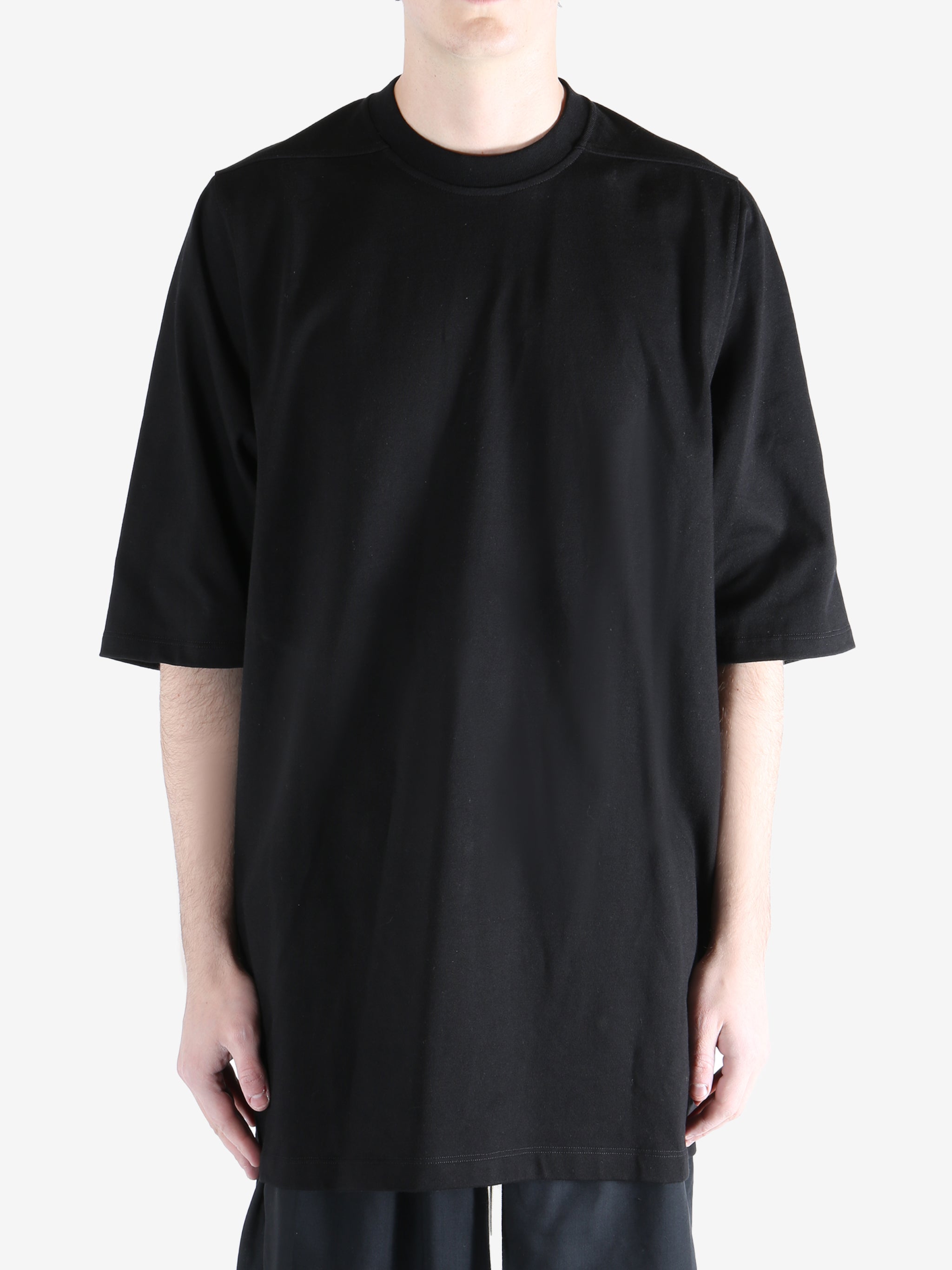 black t-shirt worn by a person, showing the t-shirt  fit