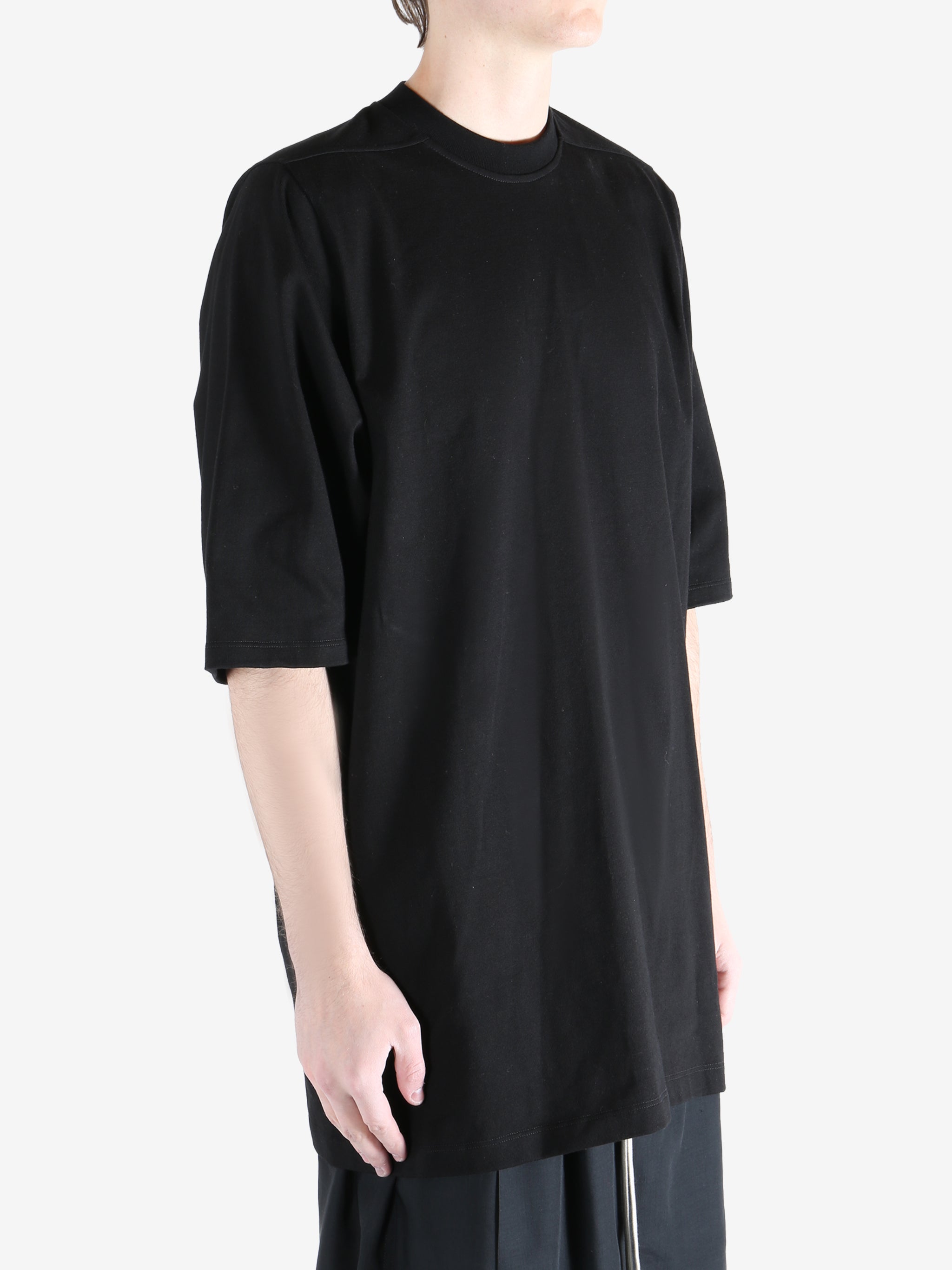 black t-shirt worn by a person, showing the t-shirt  fit