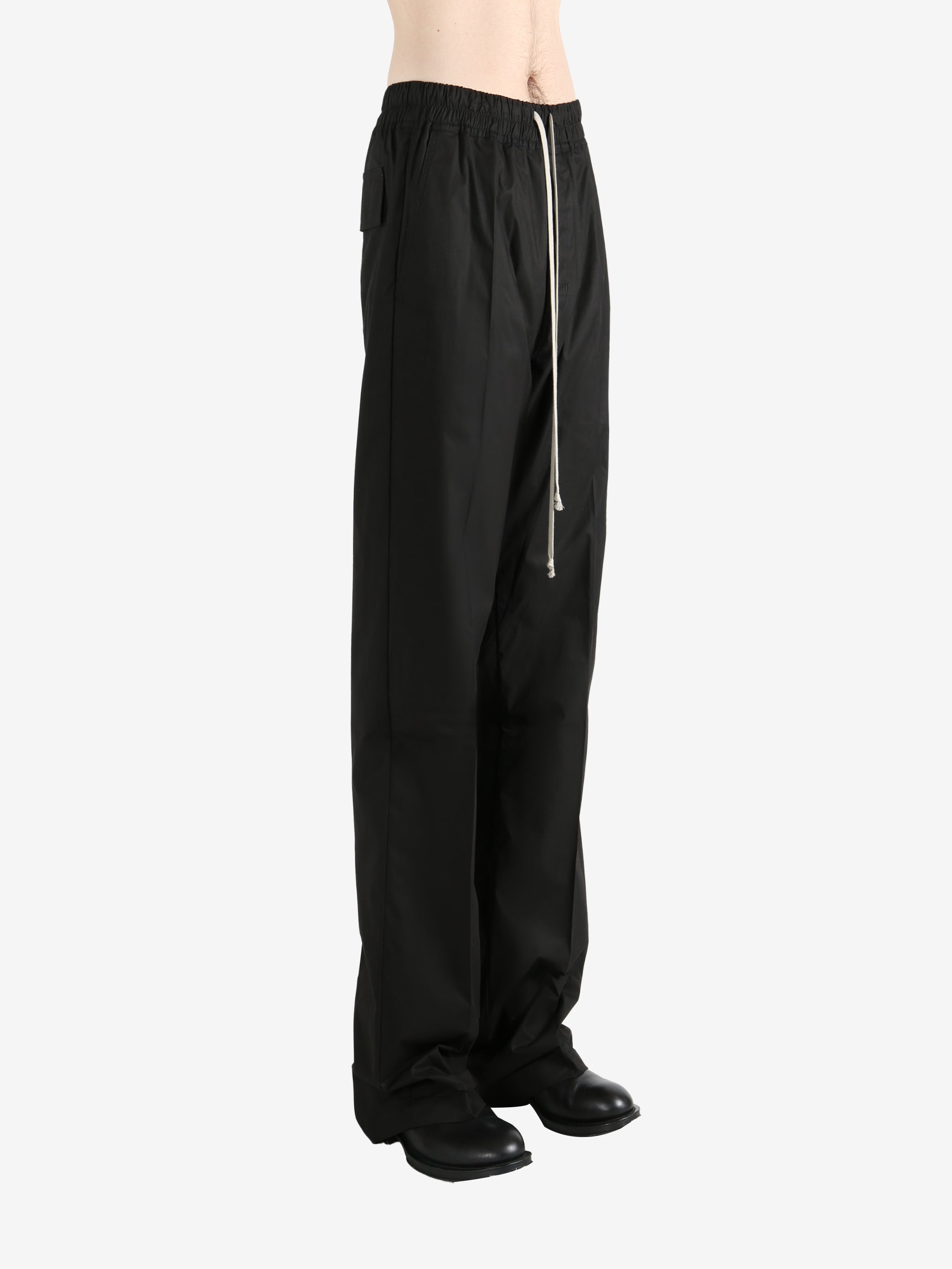 Black pants worn by a person, showing the pants' fit