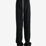 Black pants worn by a person, showing the pants' fit