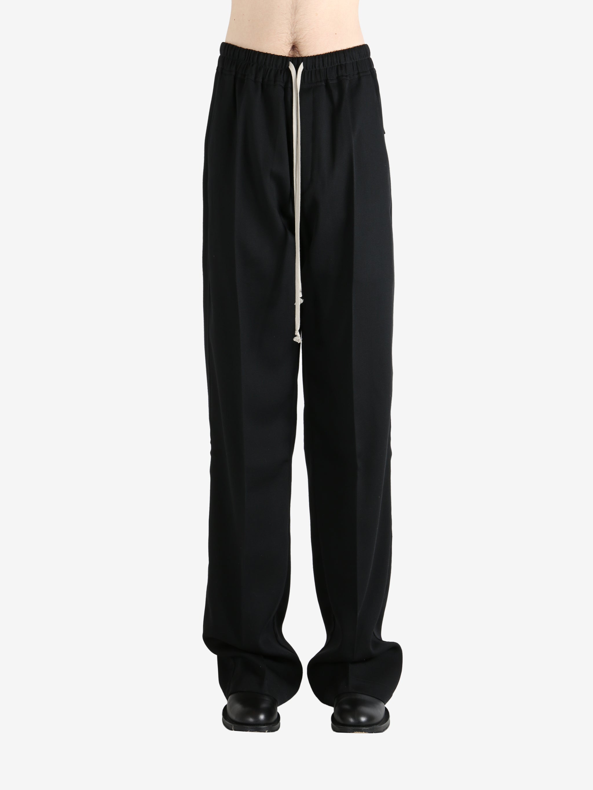 Black pants worn by a person, showing the pants' fit