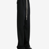 Black pants worn by a person, showing the pants' fit