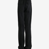 Black pants worn by a person, showing the pants' fit