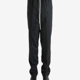 Black pants worn by a person, showing the pants' fit
