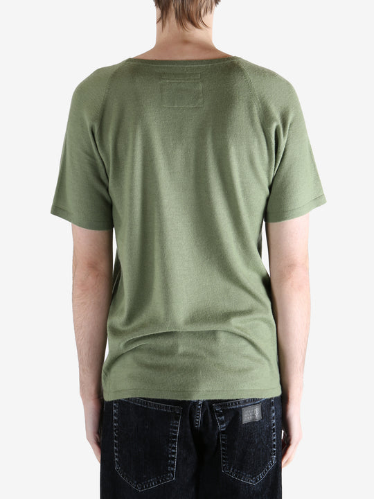 Green t-shirt worn by a person, showing the t-shirt fit