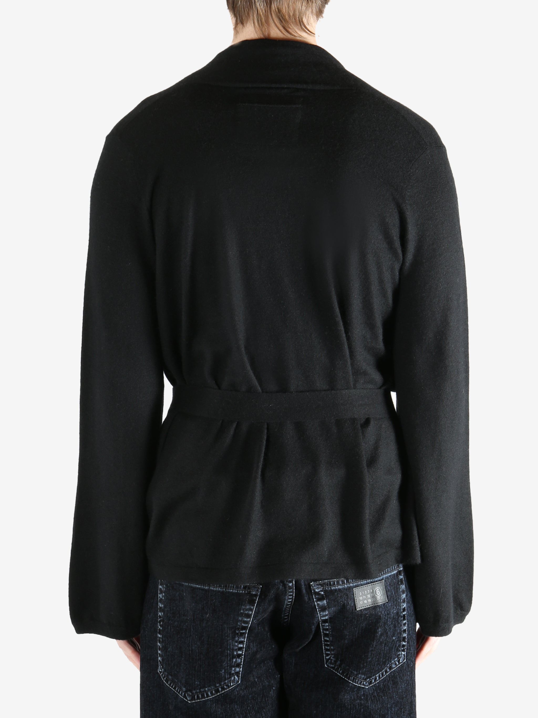 Black coat worn by a person, showing the coat's fit