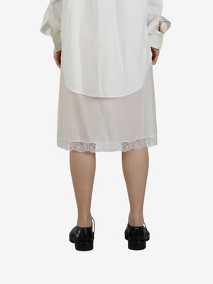 White dress worn by a person, showing the dress's fit