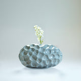 Ann Shure ceramic stone vase in azure glaze with white bloom, styled view showing floral display.
