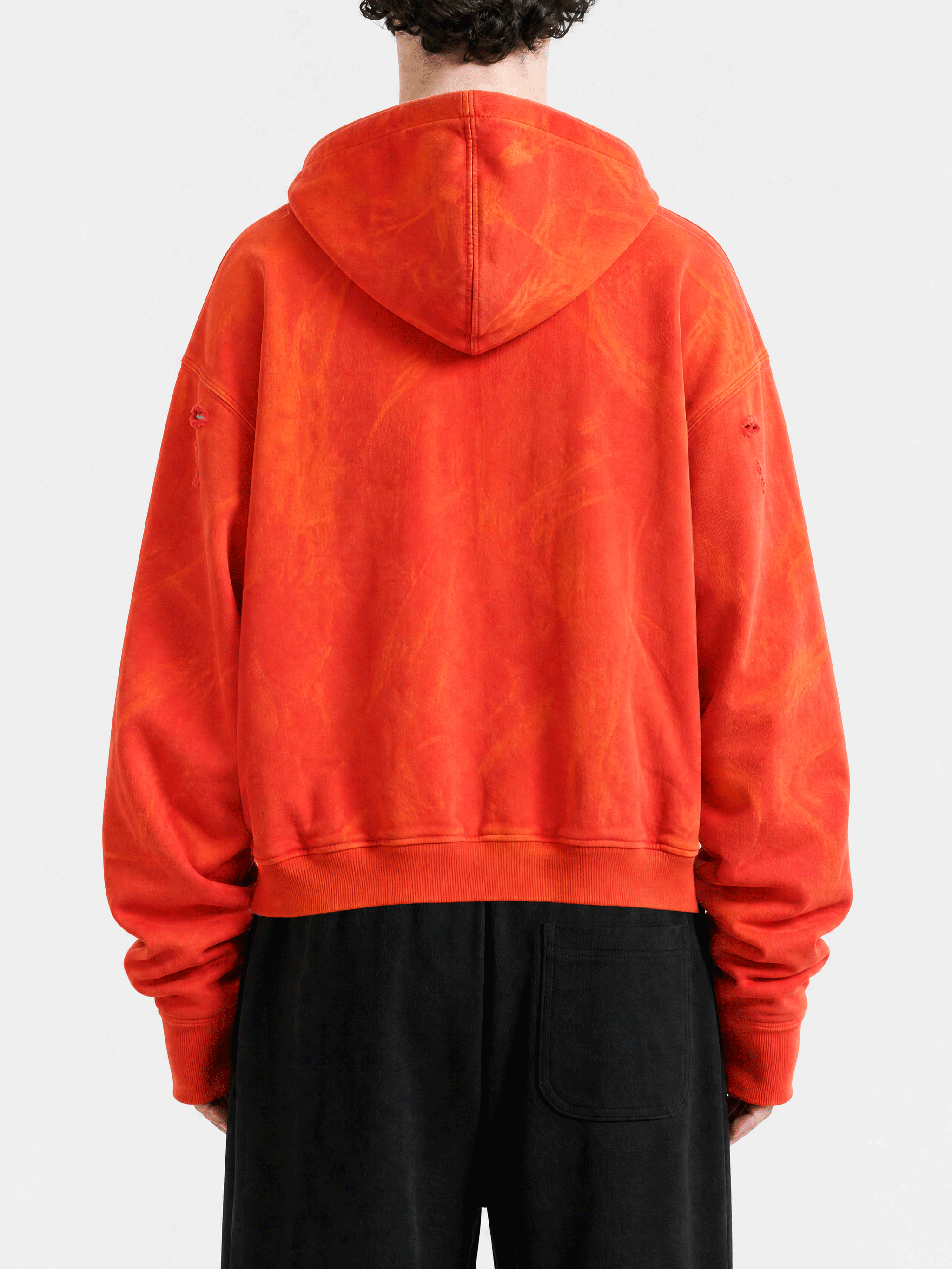 Red hoodie worn by a person, back view