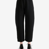 Black pants worn by a person, showing the pants's fit