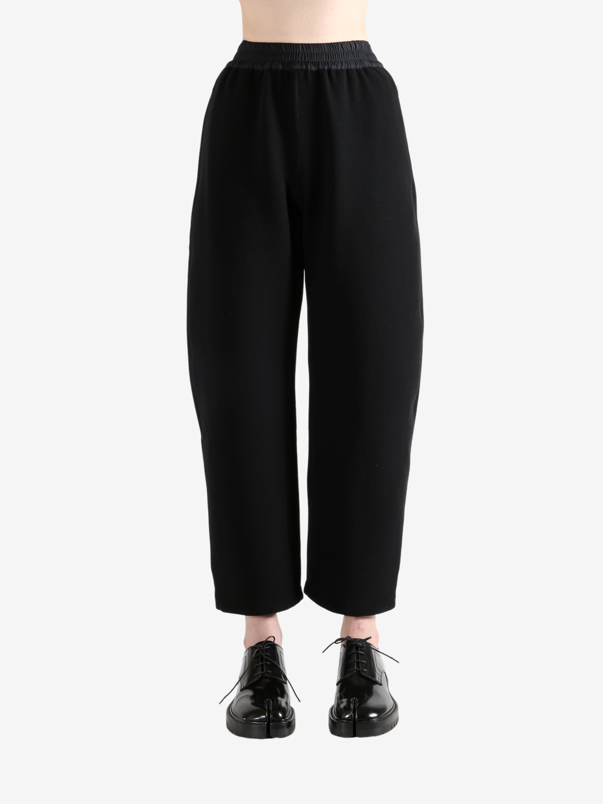 Black pants worn by a person, showing the pants's fit