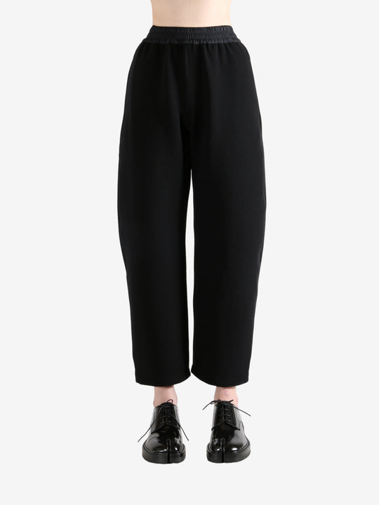 Black pants worn by a person, showing the pants's fit