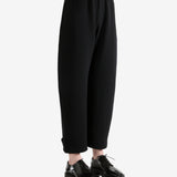 Black pants worn by a person, showing the pants's fit