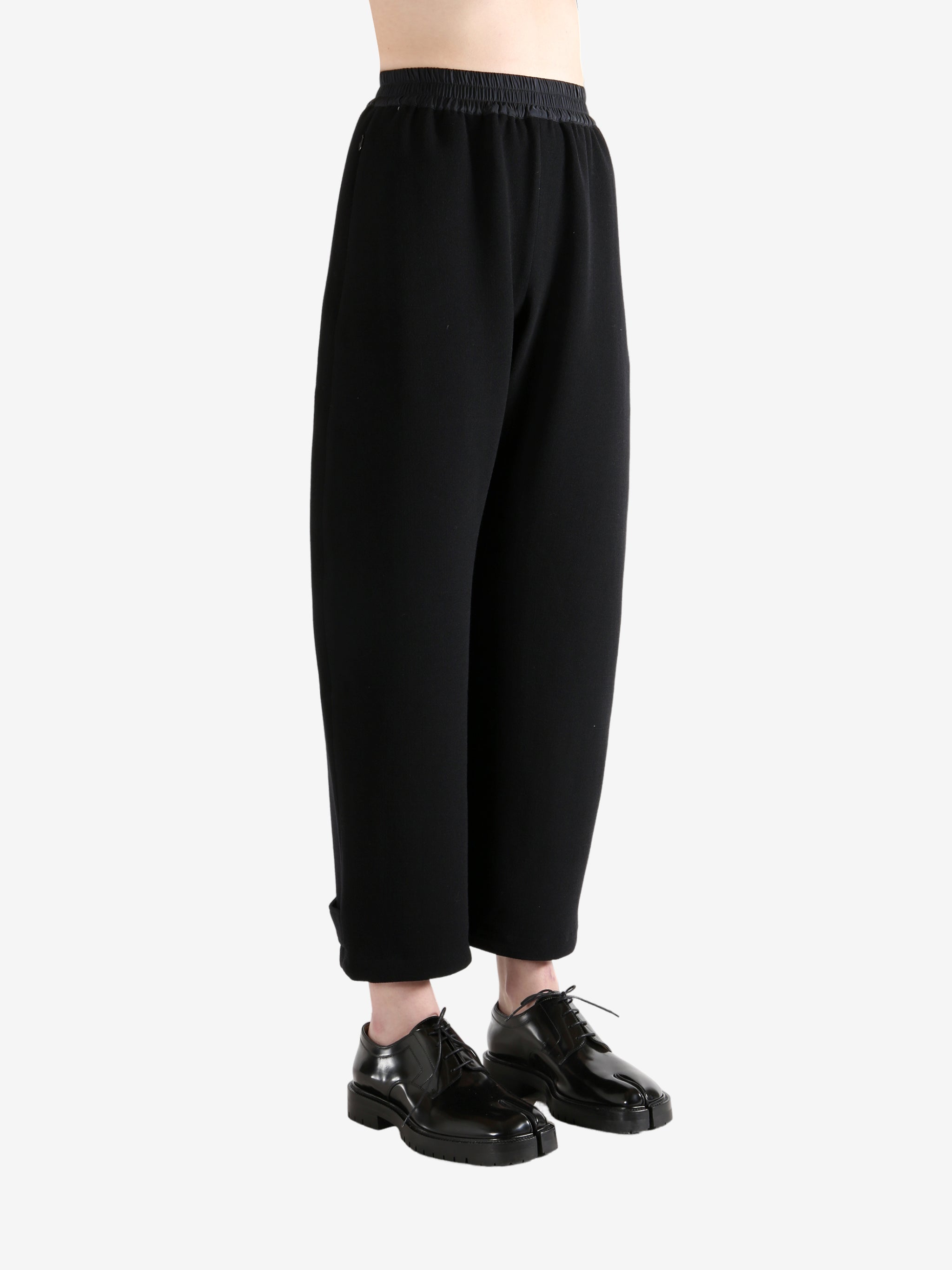 Black pants worn by a person, showing the pants's fit