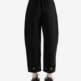 Black pants worn by a person, showing the pants's fit