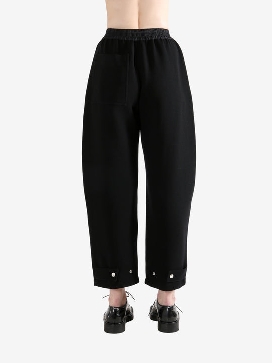 Black pants worn by a person, showing the pants's fit