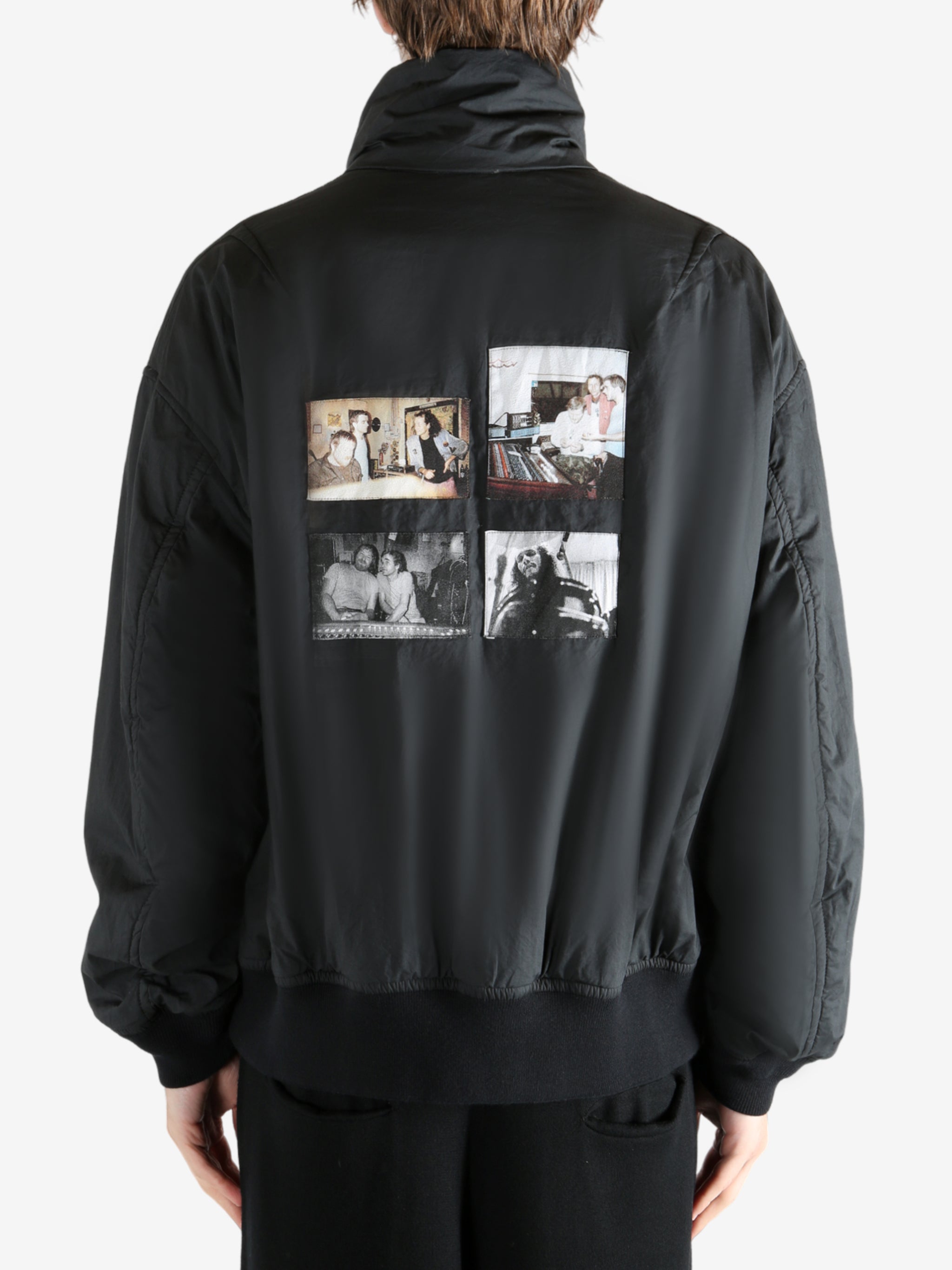 Black coat worn by a person, showing the coat's fit