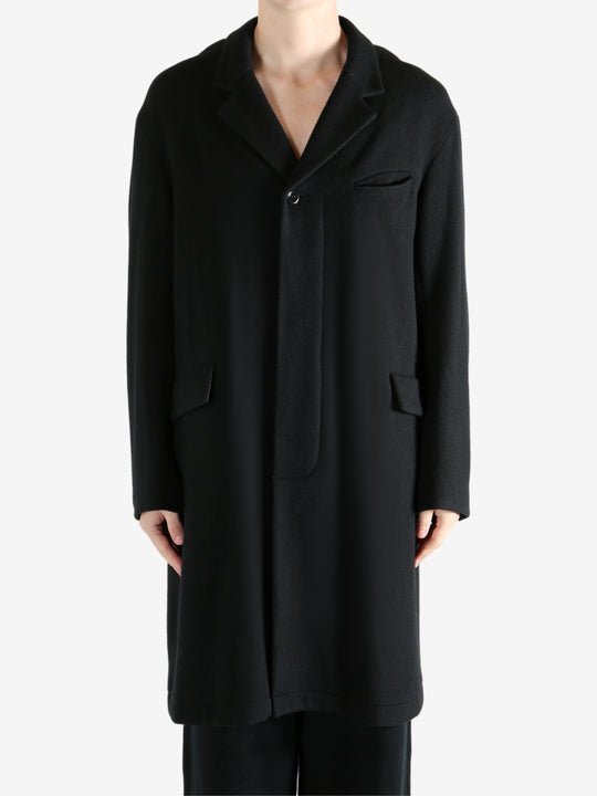 Black coat worn by a person, showing the coat's fit