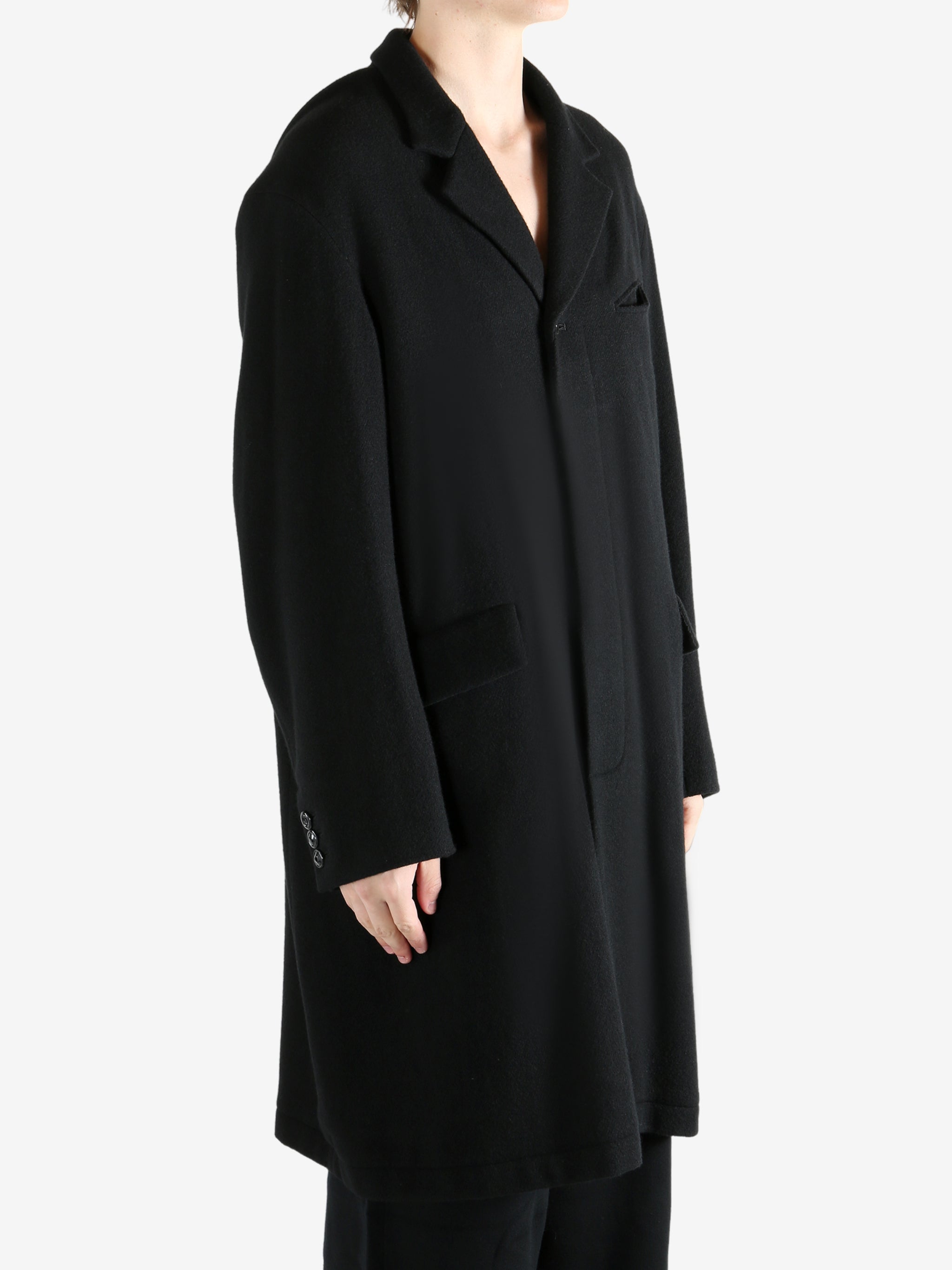 Black coat worn by a person, showing the coat's fit