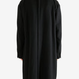 Black coat worn by a person, showing the coat's fit