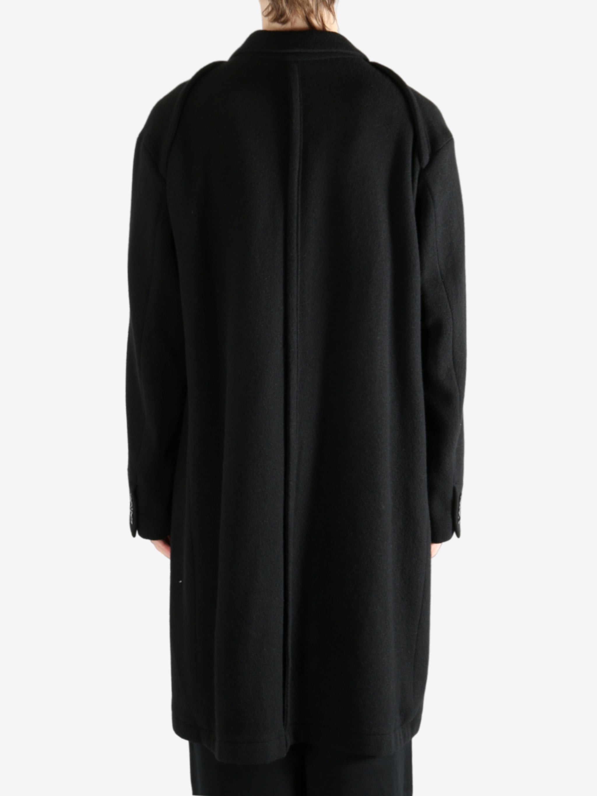 Black coat worn by a person, showing the coat's fit