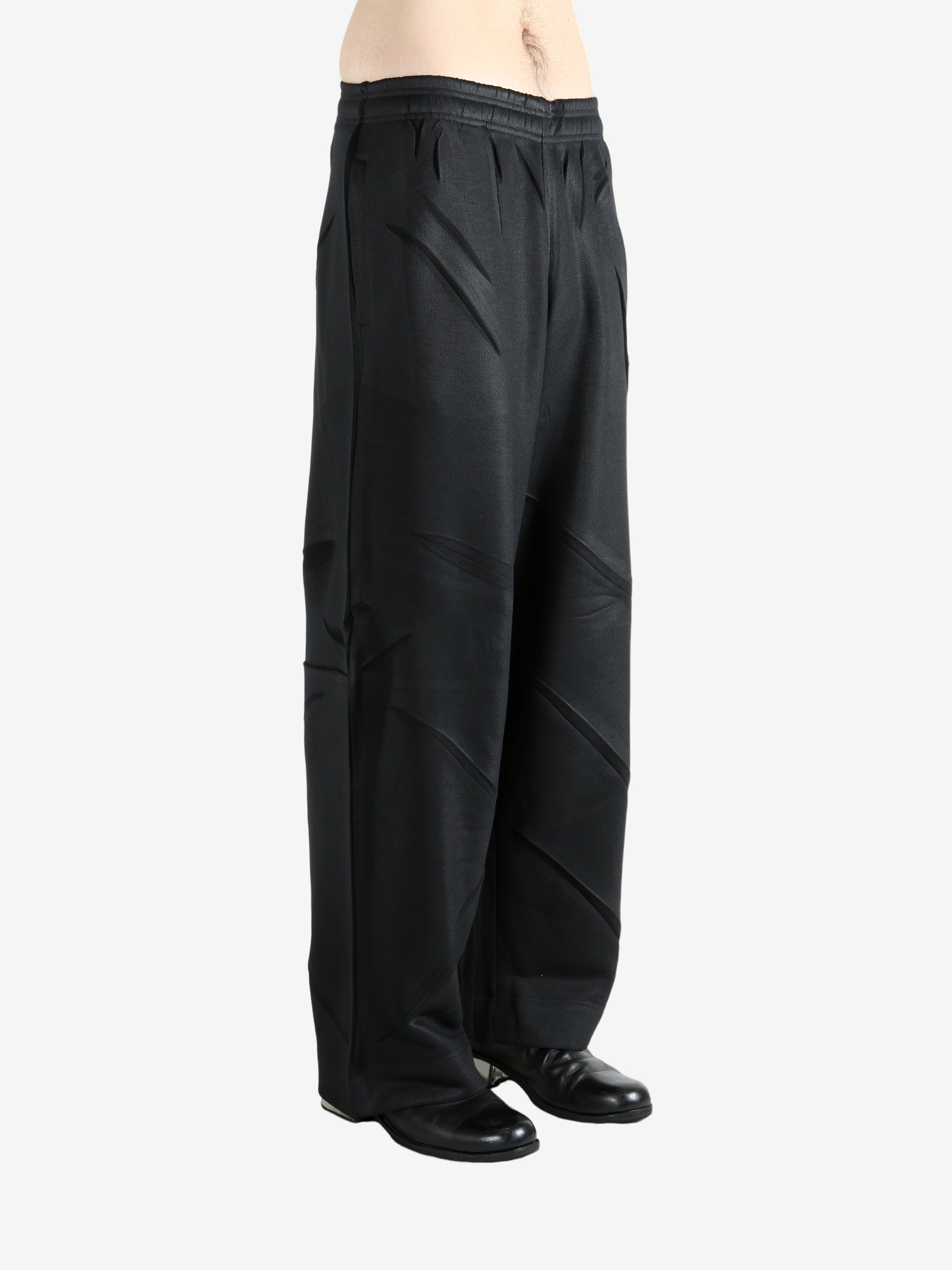 Black pants worn by a person, showing the pants' fit