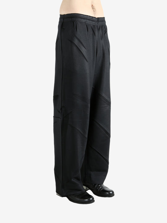 Black pants worn by a person, showing the pants' fit