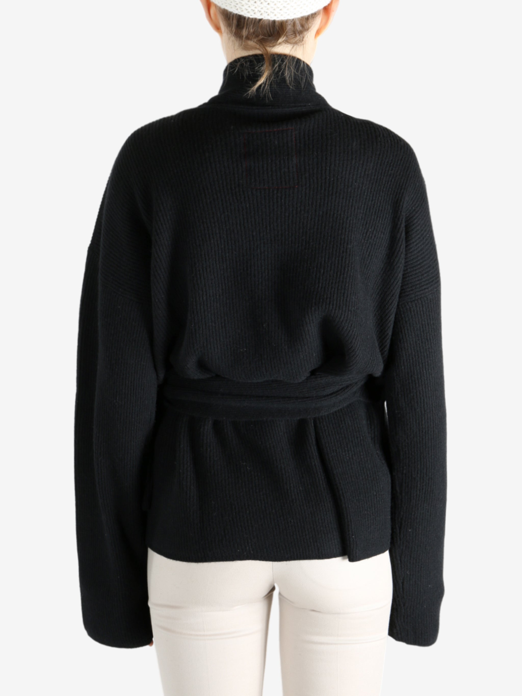Black knitwear worn by a person, showing the knitwear's fit