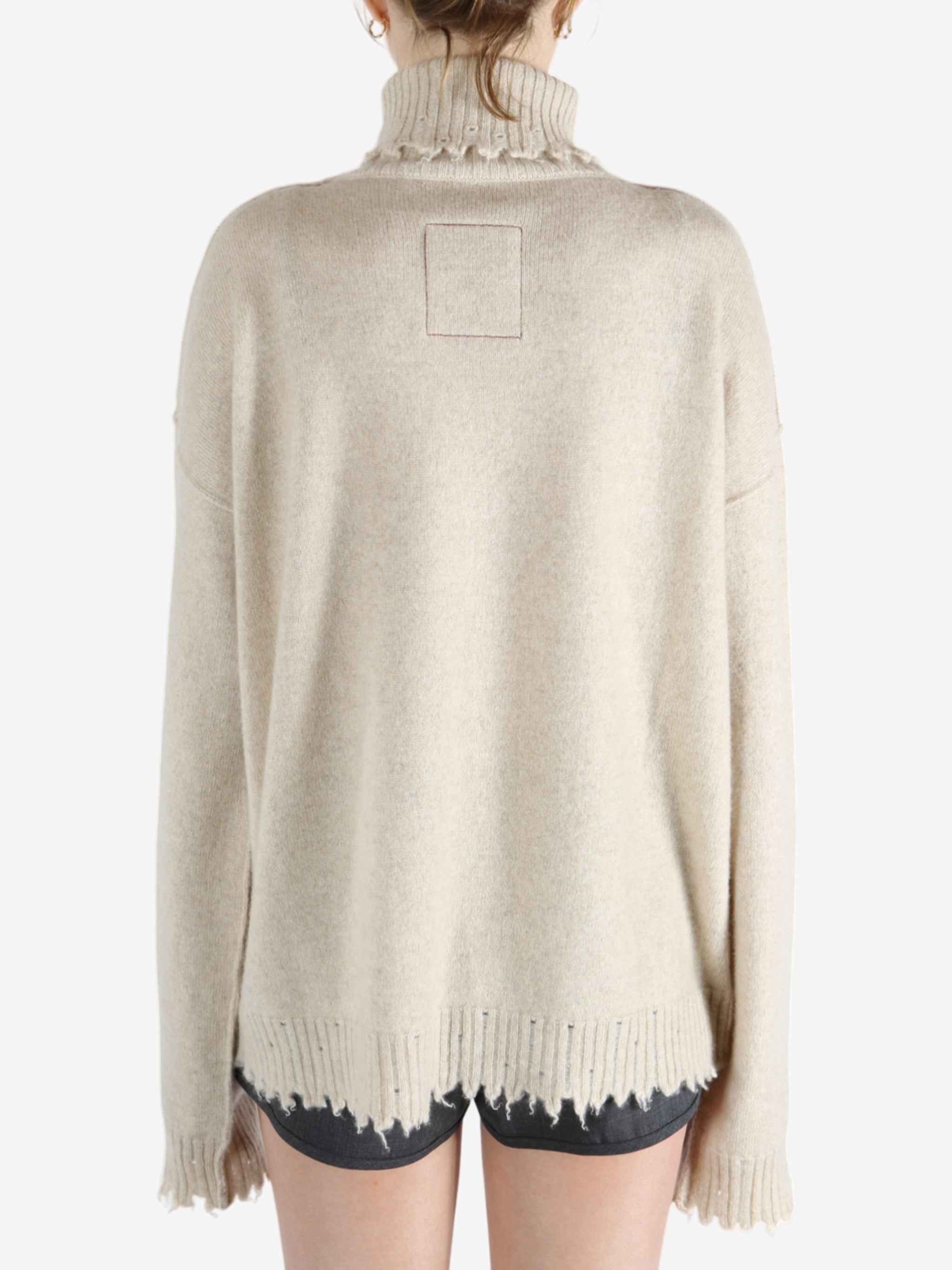 Tan knitwear worn by a person, showing the knitwear fit