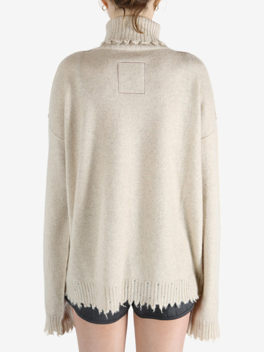 Tan knitwear worn by a person, showing the knitwear fit