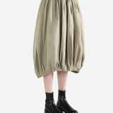 Tan skirt worn by a person, side view
