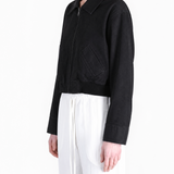 Black coat worn by a person, showing the coat fit