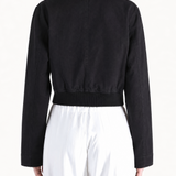 Black coat worn by a person, showing the coat fit