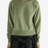 Green knitwear worn by a person, showing the knitwear's fit